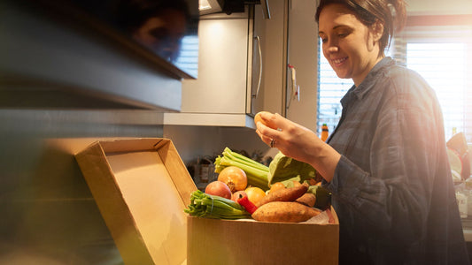 Woman Unpacking a Box of Organic Produce