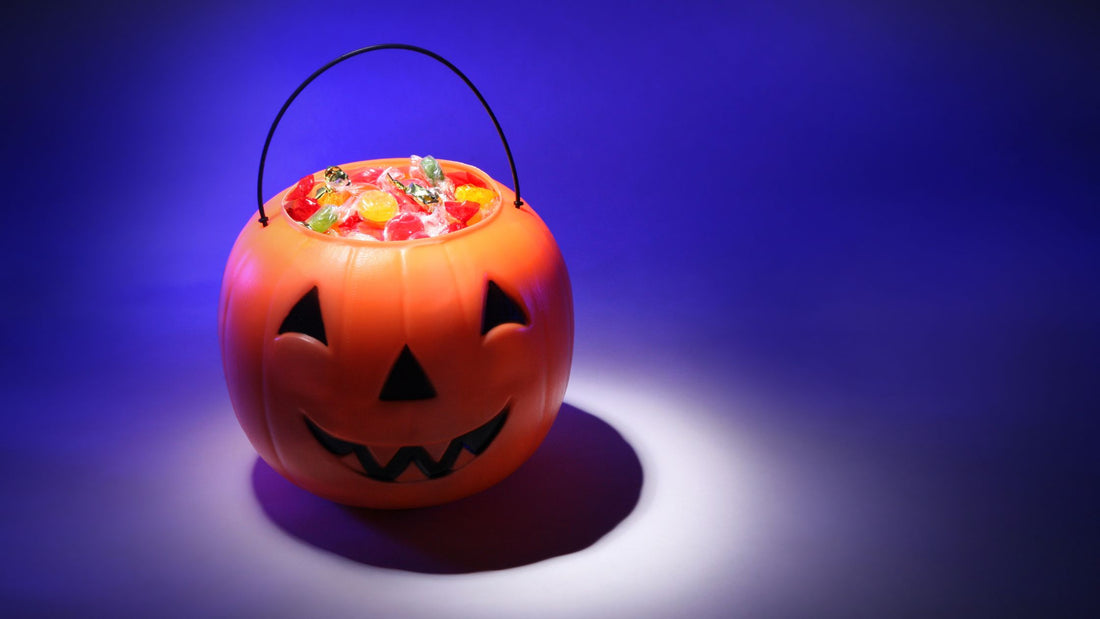 Jack-o-Lantern Candy Bucket Filled with Candy on Blue Background